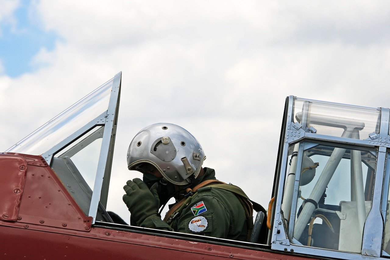 harvard pilot, adjusting oxygen mask, flying suit, cockpit, preparing for takeoff, south african air force museum, aviation